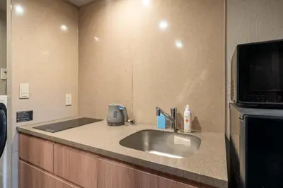 a kitchen counter with a sink and a microwave at stayme THE HOTEL\u4e0a\u91ce\u99c5\u524d in Tokyo