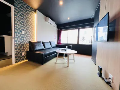 a living room with a black couch and a table at Asakusa-Smile-SM0141 in Tokyo