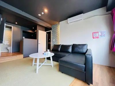 a living room with a black leather couch and a table at Asakusa-Smile-SM0141 in Tokyo
