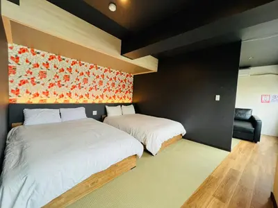 a bedroom with two beds and an orange wall at Asakusa-Smile-SM0141 in Tokyo