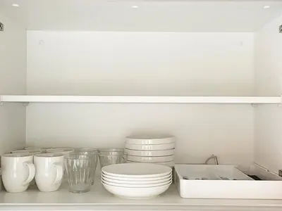 a kitchen with white plates and bowls on a shelf at PRISM Inn Komagata Asakusa in Tokyo