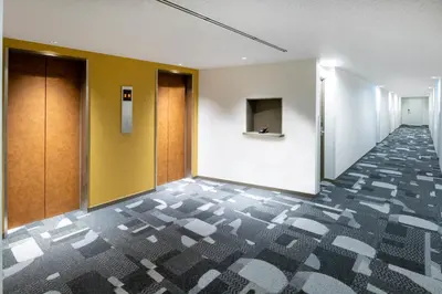 a corridor of an office building with a hallway at HOTEL MYSTAYS Nishi Shinjuku in Tokyo