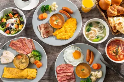 a table with plates of breakfast food on it at HOTEL MYSTAYS Nishi Shinjuku in Tokyo