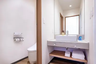 a white bathroom with a sink and a mirror at HOTEL MYSTAYS Nishi Shinjuku in Tokyo