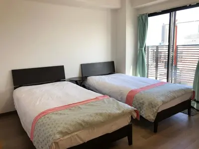 two beds in a room with a window at \u5b89\u30db\u30c6\u30eb\u30b5\u30f3\u30b7\u30e3\u30a4\u30f3 in Tokyo