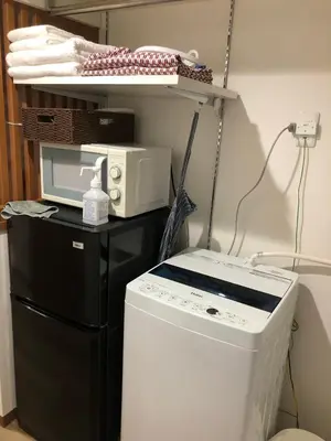 a laundry room with a washer and a microwave at \u5b89\u30db\u30c6\u30eb\u30b5\u30f3\u30b7\u30e3\u30a4\u30f3 in Tokyo