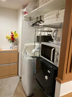 a kitchen with a microwave and a shelf with towels at \u5b89\u30db\u30c6\u30eb\u30b5\u30f3\u30b7\u30e3\u30a4\u30f3 in Tokyo