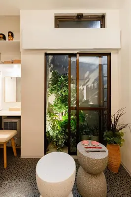 a room with a table and two stools in front of a window at Hotel Lux in Tokyo