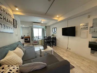 a living room with a couch and a flat screen tv at Hotel Lux in Tokyo
