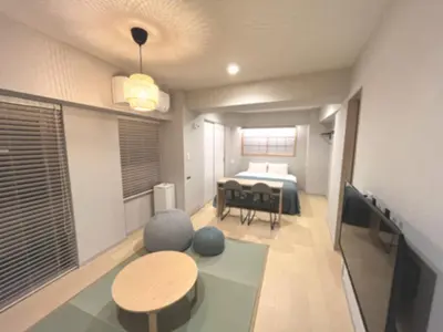 a room with a bed and a table and a dining room at KLASSO Tokyo Sumiyoshi Apartments in Tokyo