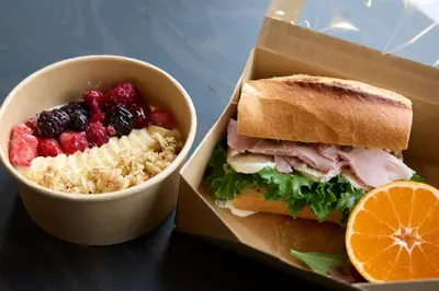a sandwich and a bowl of fruit next to a box of food at fav TOKYO RYOGOKU in Tokyo