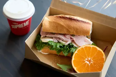 a sandwich in a box next to a cup of coffee at fav TOKYO RYOGOKU in Tokyo