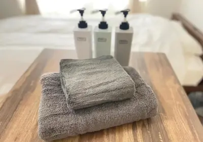 a pile of towels sitting on a wooden table at Beverly Homes Osaki by Tranova in Tokyo