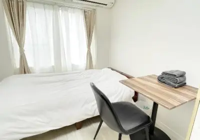 a bedroom with a bed and a desk and a chair at Beverly Homes Osaki by Tranova in Tokyo