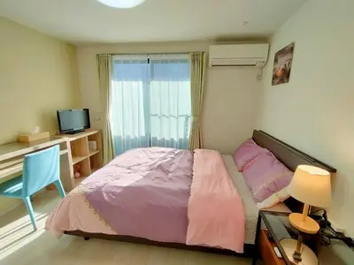 a bedroom with a bed and a desk and a television at KIKI HOUSE \u65b0\u5c0f\u5ca9 in Tokyo