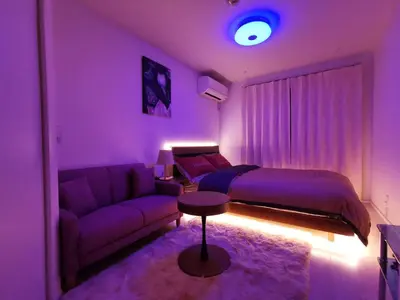 a purple bedroom with a bed and a couch at KIKI HOUSE \u65b0\u5c0f\u5ca9 in Tokyo