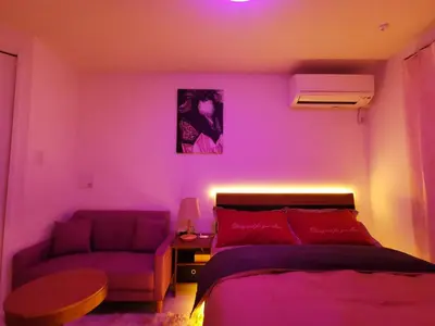 a bedroom with a purple room with a bed and a couch at KIKI HOUSE \u65b0\u5c0f\u5ca9 in Tokyo
