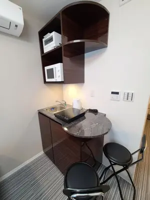 a room with a counter with a sink and two stools at \u30d1\u30fc\u30ea\u30fc\u30d5\u30e9\u30c3\u30c4\u54c1\u5ddd\u9ad8\u8f2a\u53f0 PEARLY FLATS Shinagawa Takanawadai in Tokyo