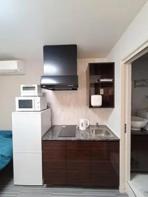 a small kitchen with a sink and a microwave at \u30d1\u30fc\u30ea\u30fc\u30d5\u30e9\u30c3\u30c4\u54c1\u5ddd\u9ad8\u8f2a\u53f0 PEARLY FLATS Shinagawa Takanawadai in Tokyo