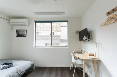 a bedroom with a bed and a desk and a window at 5963 Hotel Higashi Ikebukuro in Tokyo