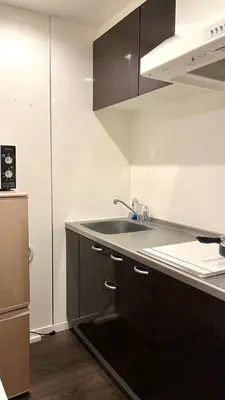 a kitchen with black cabinets and a sink at 5963 Hotel Higashi Ikebukuro in Tokyo