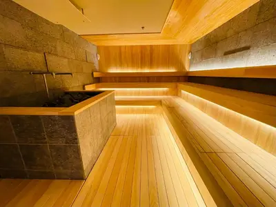 a japanese sauna with a wooden floor and a tub at SPABLIC INN - Capsule Hatago Akasaka in Tokyo