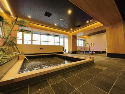 a large room with a pond in the middle of a building at SPABLIC INN - Capsule Hatago Akasaka in Tokyo