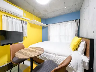 a bedroom with a bed and a table and a tv at lON\u6e0b\u8c37\u672c\u753a in Tokyo