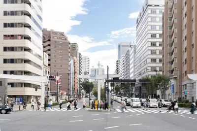 a group of people crossing a street in a city at lON\u6e0b\u8c37\u672c\u753a in Tokyo