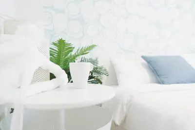 a white living room with a white chair and a table at Shinjuku Mermaid Apartment in Tokyo