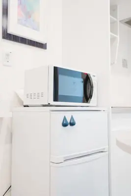 a microwave oven sitting on top of a refrigerator at Shinjuku Mermaid Apartment in Tokyo