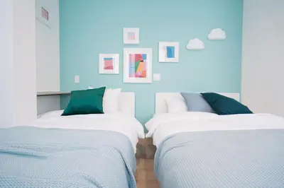 two beds in a room with blue walls at Shinjuku Mermaid Apartment in Tokyo