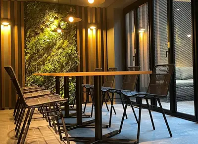 a table and chairs in a room with a balcony at HOTEL AMANEK Shinjuku Kabukicho in Tokyo