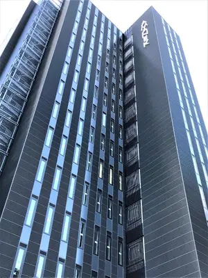 a tall black building with a sign on it at HOTEL AMANEK Shinjuku Kabukicho in Tokyo
