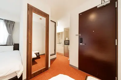 a hotel room with a door leading to a bedroom at Serorin Light Hotel Tokyo in Tokyo