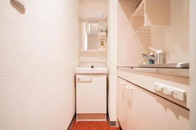 a white kitchen with a sink and a counter at Serorin Light Hotel Tokyo in Tokyo