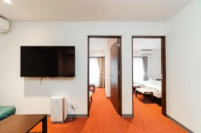 a hotel room with a bed and a television and a room at Serorin Light Hotel Tokyo in Tokyo