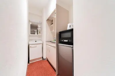 a small kitchen with a stove and a microwave at Serorin Light Hotel Tokyo in Tokyo