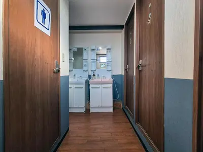 a hallway to a bathroom with a sink and a bathroom at Tokyo House INN in Tokyo