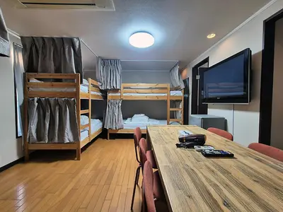 a room with a table and a room with bunk beds at Tokyo House INN in Tokyo