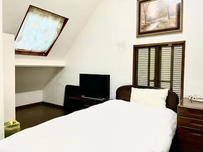 a bedroom with a bed and a desk with a television at \u65b0\u5bbf\u3078\u884c\u304f\u4fbf\u5229\u306e\u4e00\u8ed2\u5bb6 in Tokyo