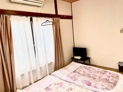 a bedroom with a bed and a large window at \u65b0\u5bbf\u3078\u884c\u304f\u4fbf\u5229\u306e\u4e00\u8ed2\u5bb6 in Tokyo