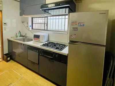 a kitchen with a stainless steel refrigerator and a sink at \u65b0\u5bbf\u3078\u884c\u304f\u4fbf\u5229\u306e\u4e00\u8ed2\u5bb6 in Tokyo