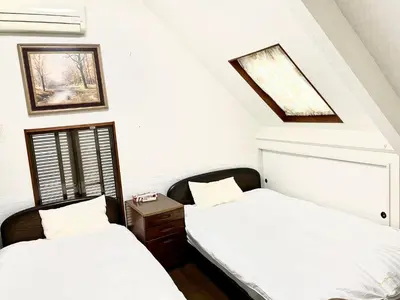 two beds in a room with white walls at \u65b0\u5bbf\u3078\u884c\u304f\u4fbf\u5229\u306e\u4e00\u8ed2\u5bb6 in Tokyo
