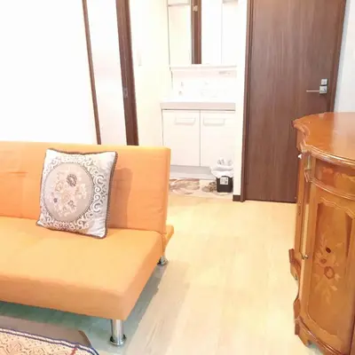 a living room with a couch with a pillow on it at \u65b0\u5bbf\u3078\u884c\u304f\u4fbf\u5229\u306e\u4e00\u8ed2\u5bb6 in Tokyo
