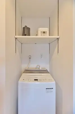 a washing machine in a room with a shelf at TORA HOTEL Sensoji \u5bc5\u30db\u30c6\u30eb \u6d45\u8349\u5bfa in Tokyo