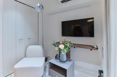 a living room with a chair and a tv at TORA HOTEL Sensoji \u5bc5\u30db\u30c6\u30eb \u6d45\u8349\u5bfa in Tokyo
