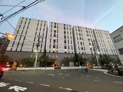 a large building with a person on a bike in front of it at TORA HOTEL Sensoji \u5bc5\u30db\u30c6\u30eb \u6d45\u8349\u5bfa in Tokyo