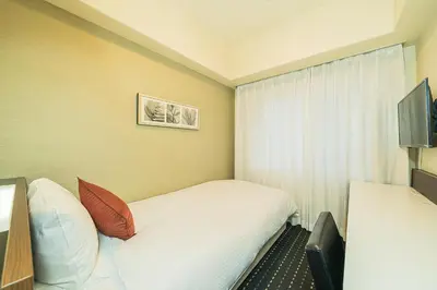a hotel room with a bed and a television at Kanda Station Hotel in Tokyo
