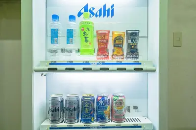 a refrigerator filled with bottles and cans of drinks at Kanda Station Hotel in Tokyo